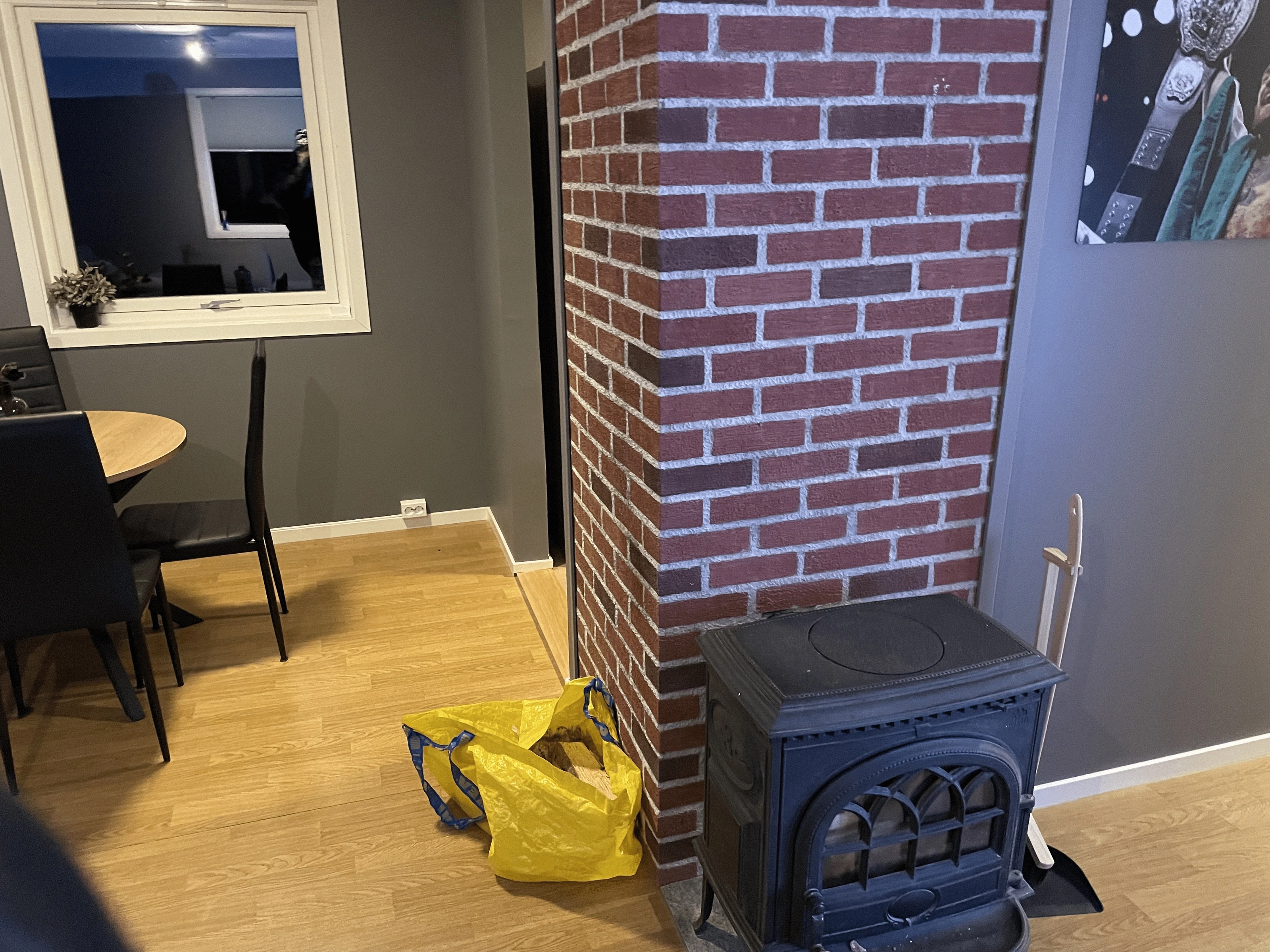 Fireplace with a brick surround and wood stove in the living room after renovation.