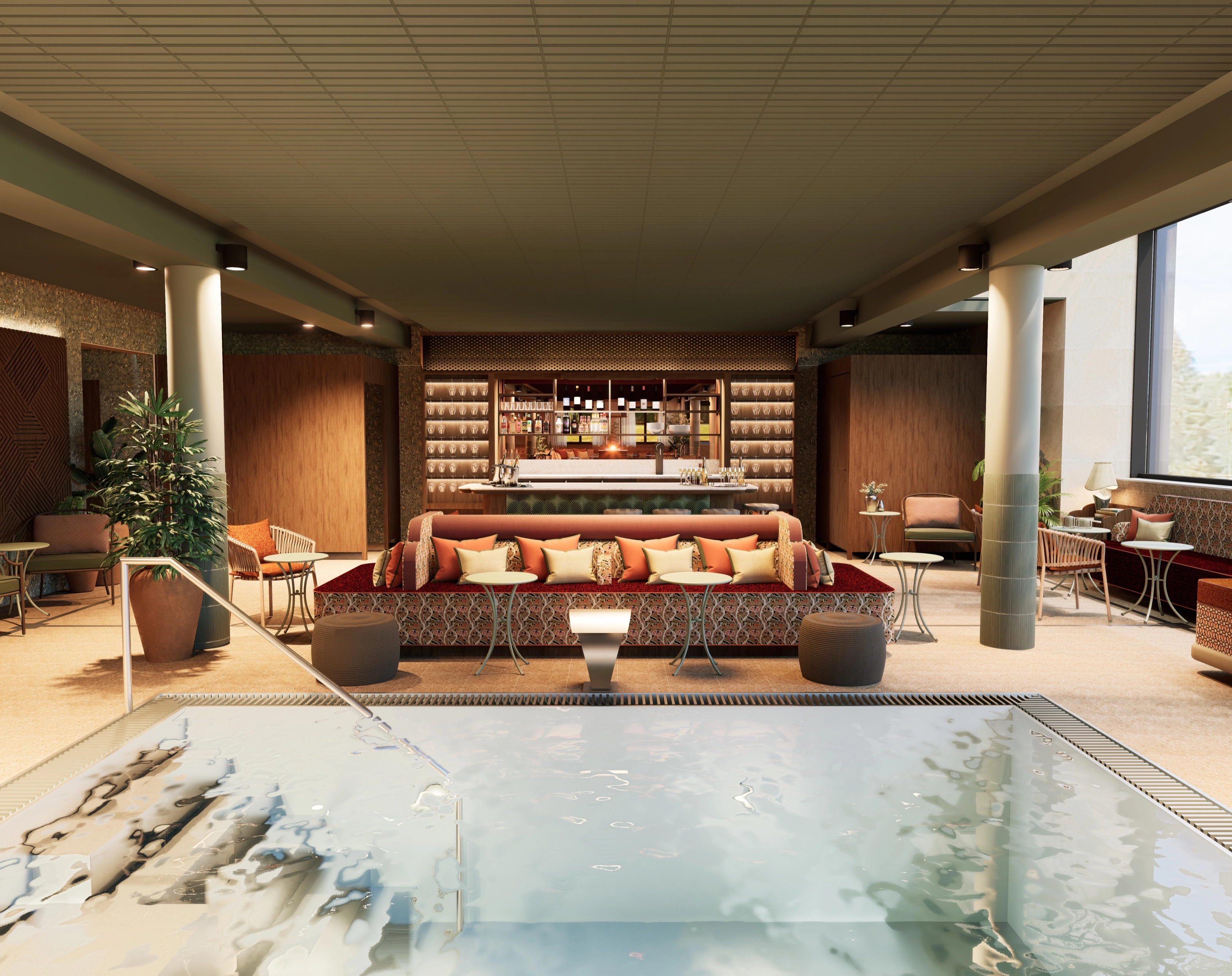 Sunken pool in the foreground, a long upholstered sofa, and the bar at the back of the pool lounge.