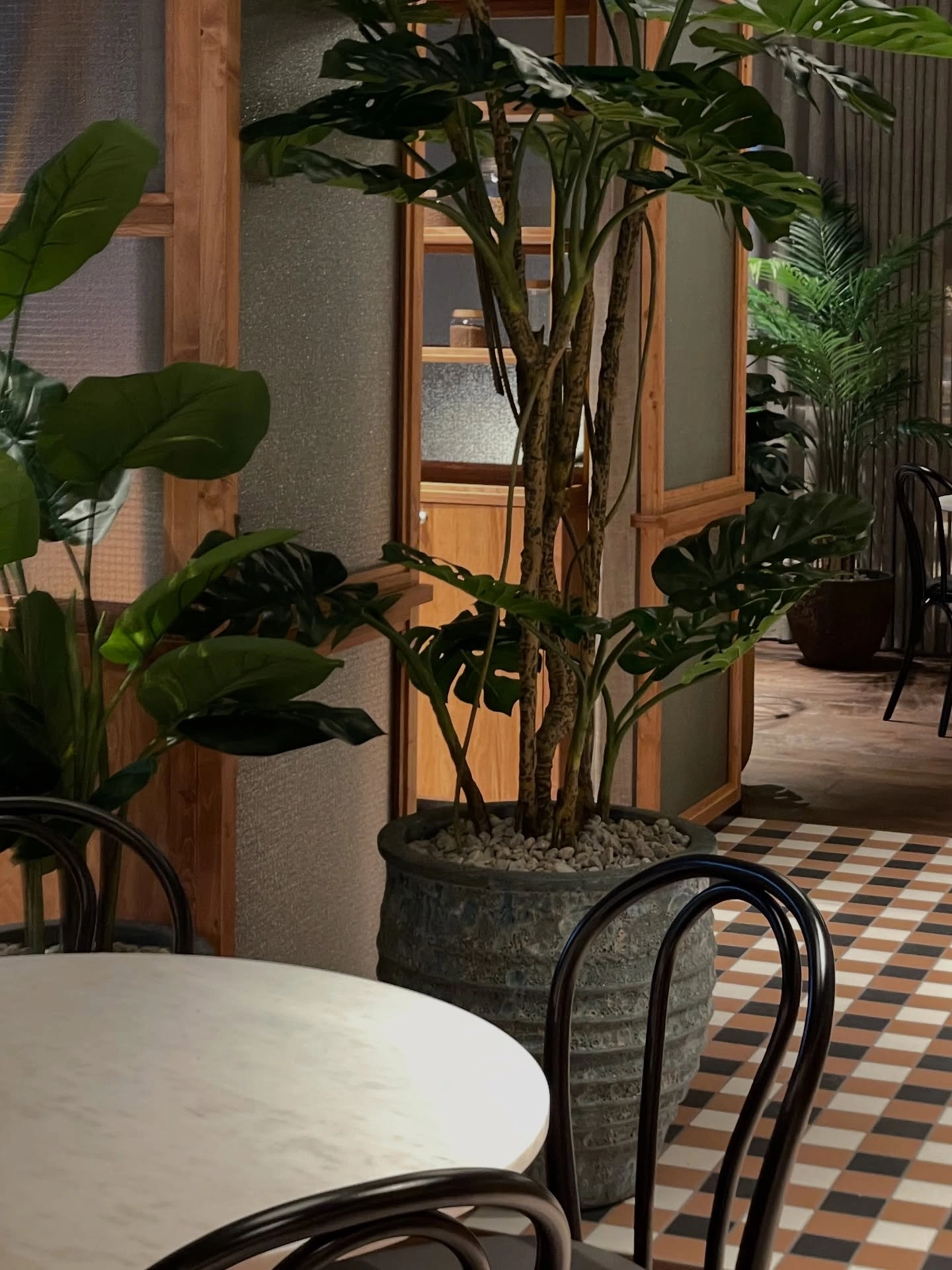 Rendering of the entrance area with plants and a checkered floor in the bistro.